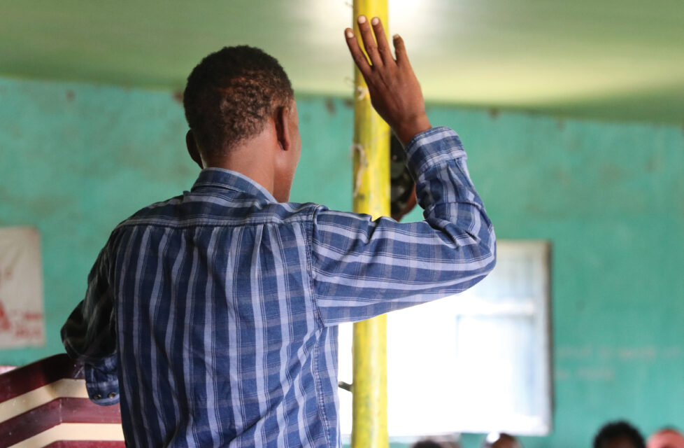 man raises his hand in worship